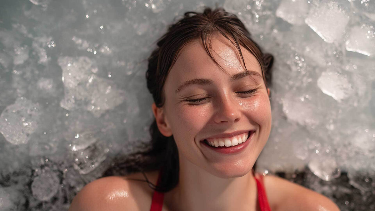 A woman smiling with her eyes closed against a wall of crushed ice