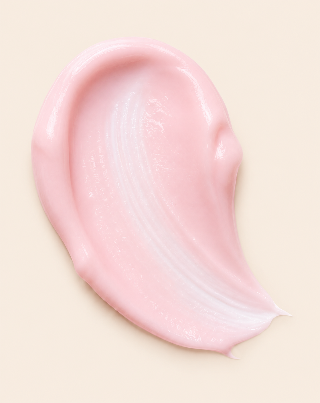 A thick swatch of pale pink cream spread on a neutral background